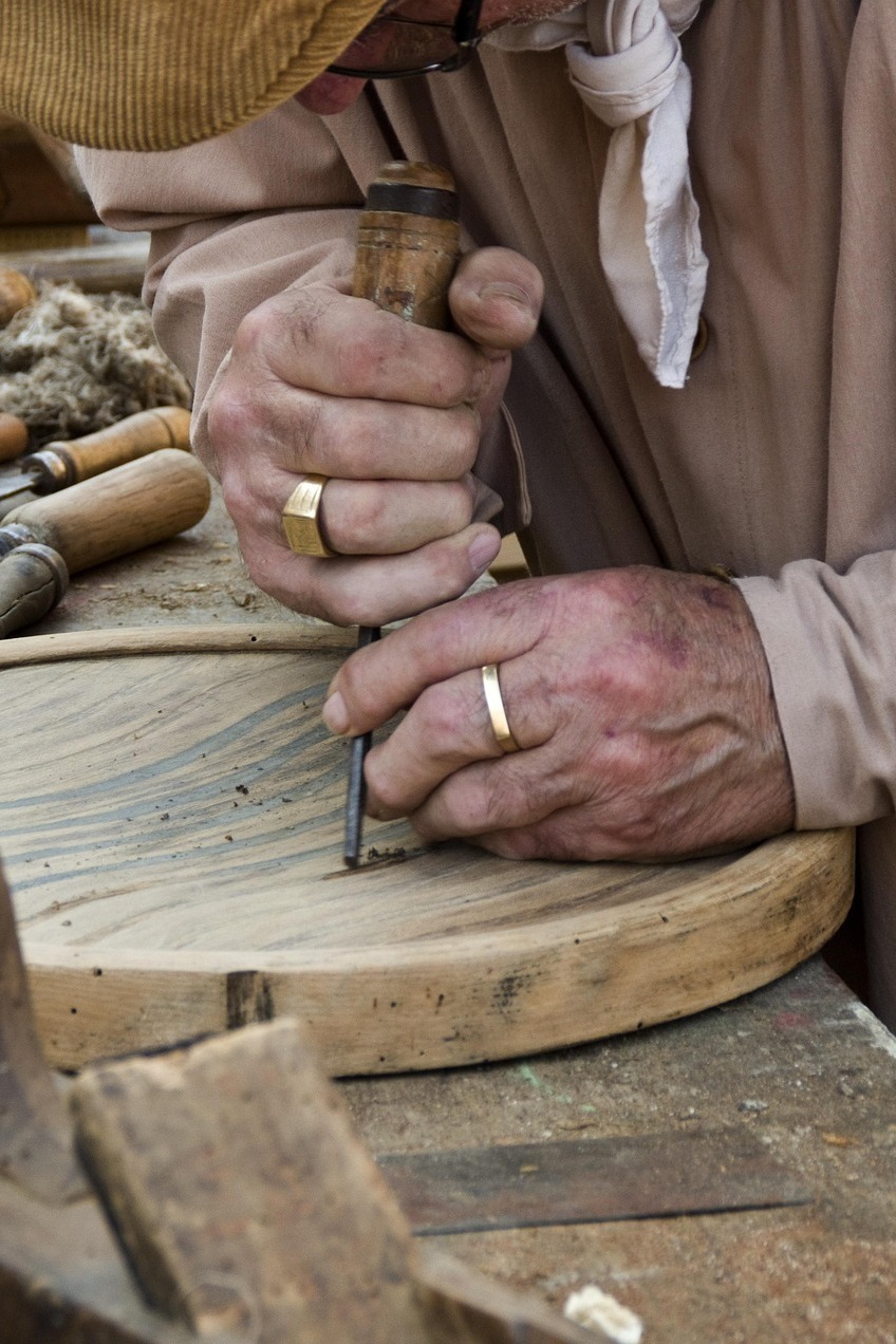 Close-up of artisan hand-carving wood by hand, showcasing craftsmanship behind curio products for wholesale